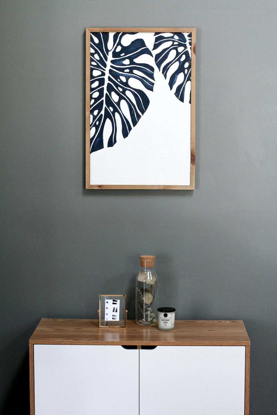 a picture hanging on a wall above a dresser