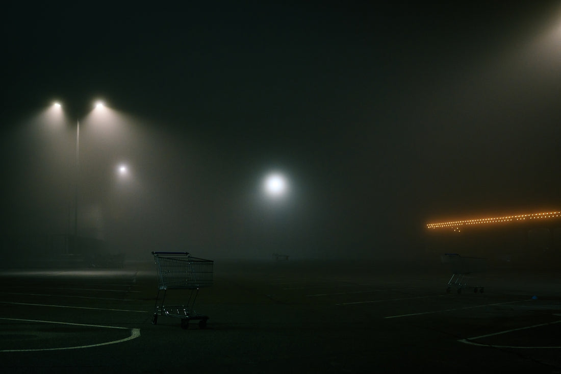 a foggy parking lot with a shopping cart in the middle of it